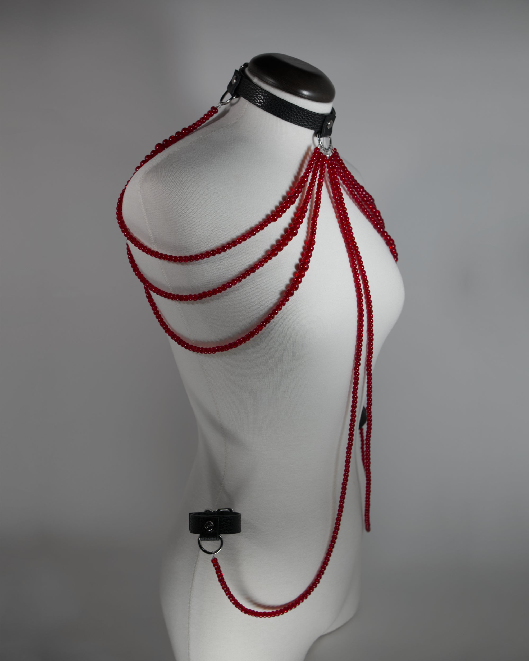 leather choker inspired by persephone with red beads chains draping on the shoulders and cuffs attached to the choker