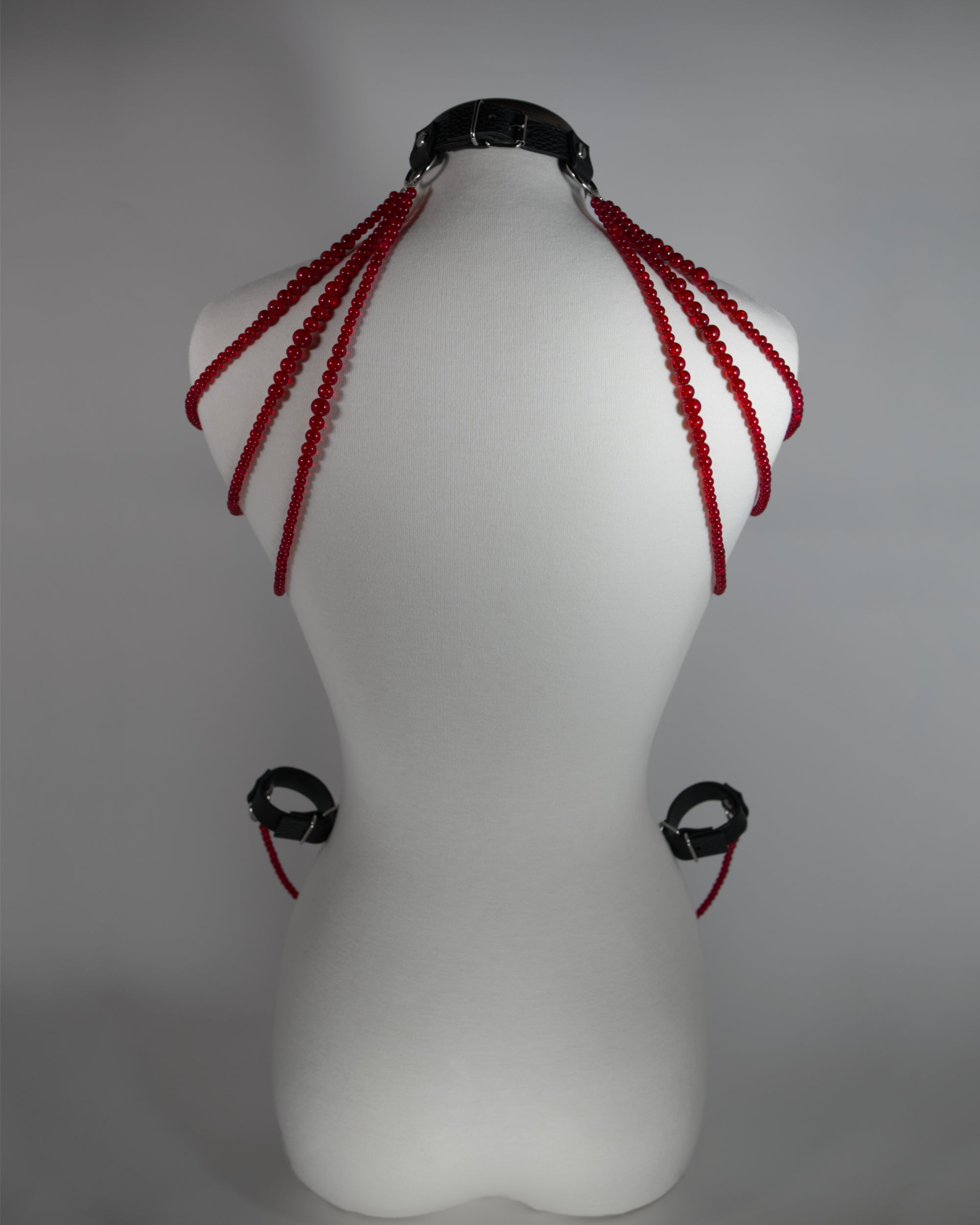 leather choker inspired by persephone with red beads chains draping on the shoulders and cuffs attached to the choker