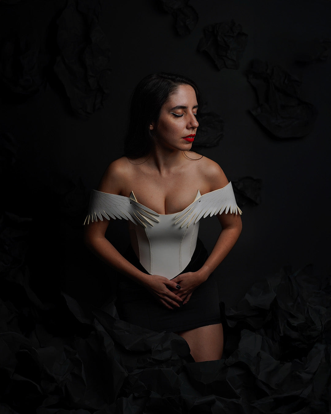 model wearing white leather corset inspired by pegasus featuring laserut wings as draping shoulder straps